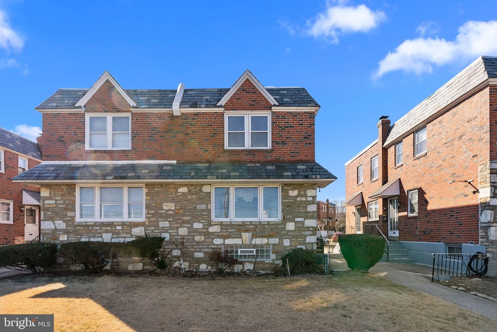 rear view of property with stone siding and a high end roof