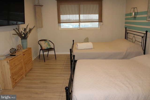 bedroom featuring baseboards and light wood finished floors