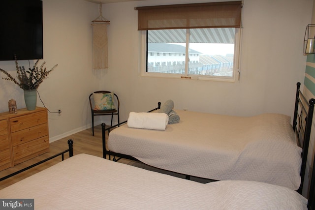 bedroom with baseboards and wood finished floors