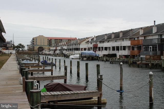 view of dock with a residential view and a water view