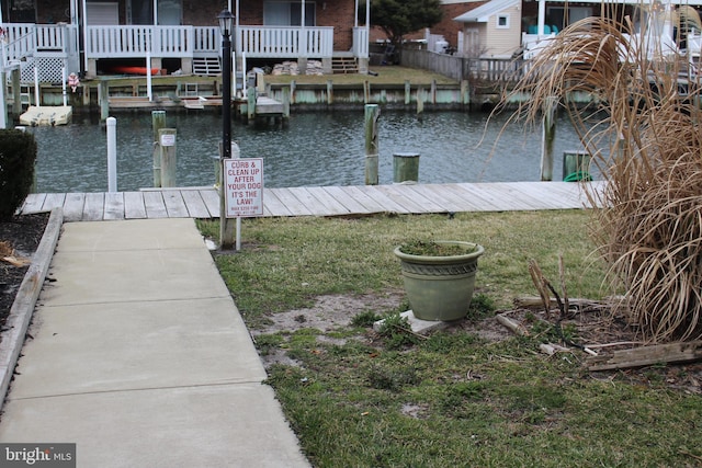 dock area featuring a lawn and a water view