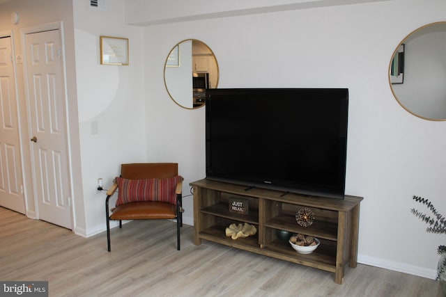 living area featuring baseboards and wood finished floors