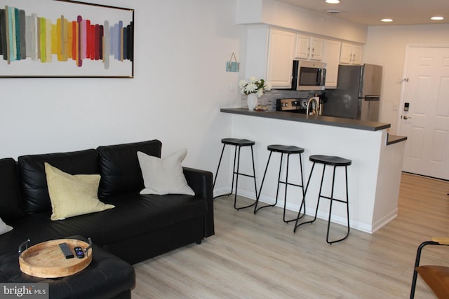 living room with recessed lighting and light wood-style flooring