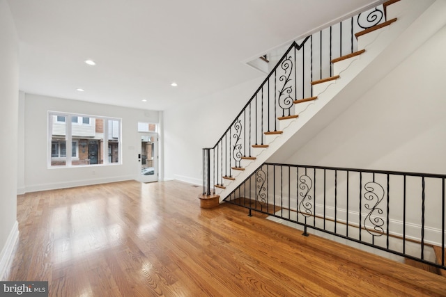 interior space with baseboards, stairway, wood finished floors, and recessed lighting