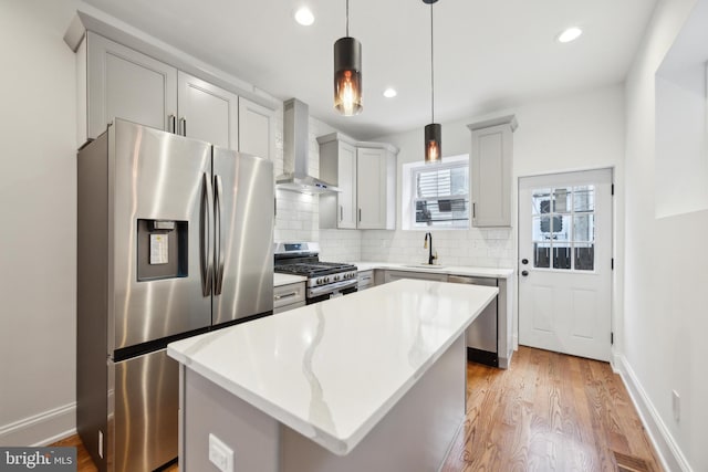 kitchen with wall chimney exhaust hood, a sink, stainless steel appliances, light countertops, and backsplash