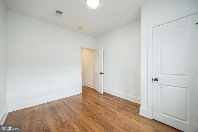 unfurnished bedroom featuring light wood-style floors, visible vents, and baseboards