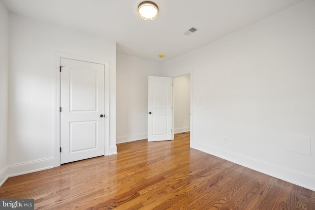 unfurnished bedroom with light wood-style floors, visible vents, and baseboards