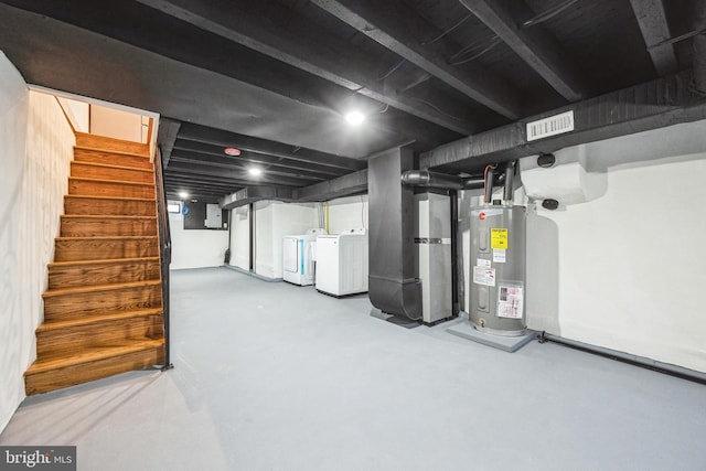 finished basement with electric panel, visible vents, washer and clothes dryer, stairs, and water heater