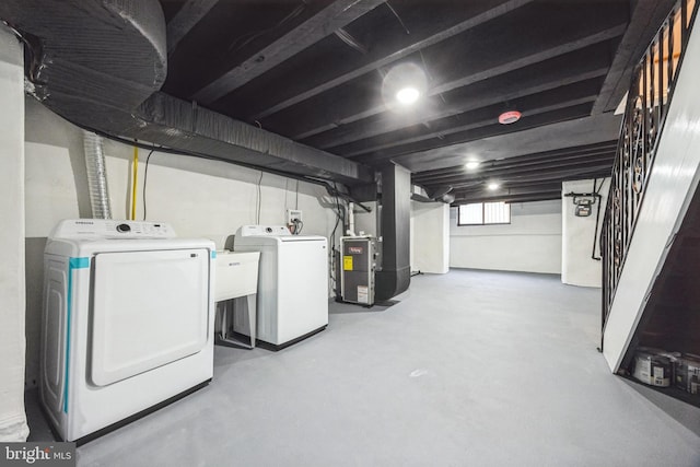 basement with heating unit, washing machine and dryer, and stairs