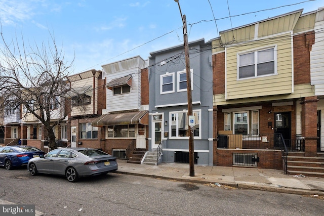 townhome / multi-family property with entry steps and brick siding