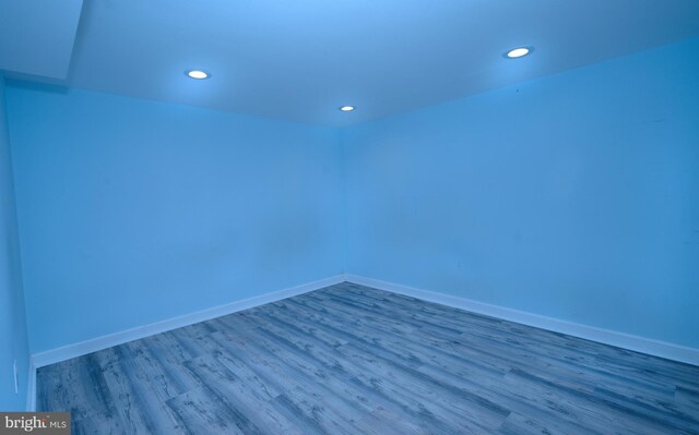 spare room with recessed lighting, wood finished floors, and baseboards