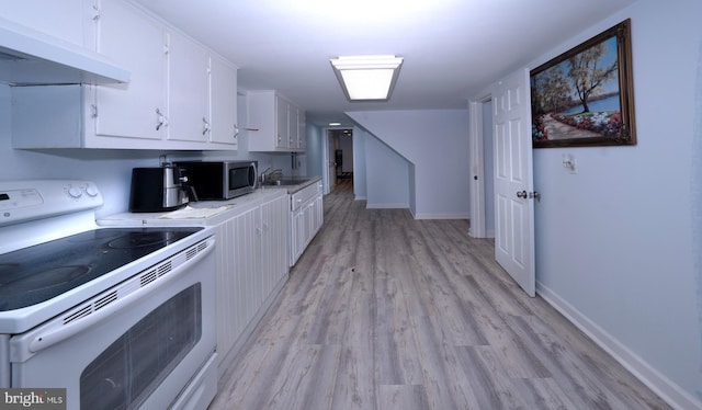 kitchen featuring white electric range oven, a sink, white cabinets, under cabinet range hood, and stainless steel microwave