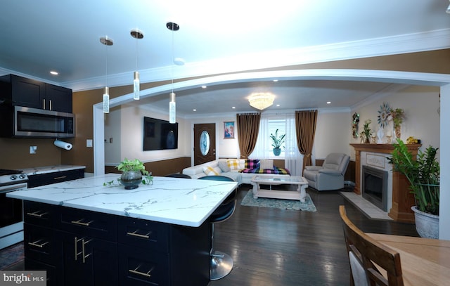 kitchen featuring dark wood finished floors, ornamental molding, range with electric cooktop, stainless steel microwave, and open floor plan