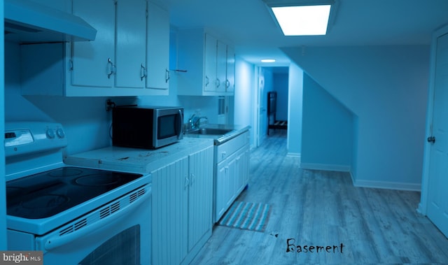 kitchen featuring stainless steel microwave, light countertops, light wood-style flooring, exhaust hood, and white electric range