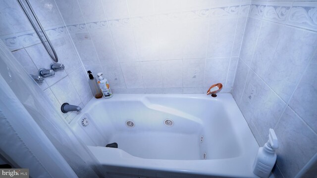 full bathroom featuring a whirlpool tub