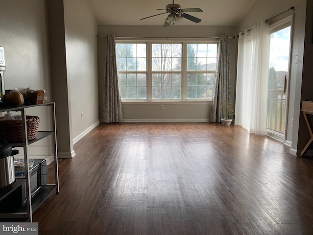 interior space with lofted ceiling, wood finished floors, a ceiling fan, and baseboards