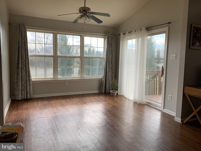 spare room with a healthy amount of sunlight, wood finished floors, and lofted ceiling