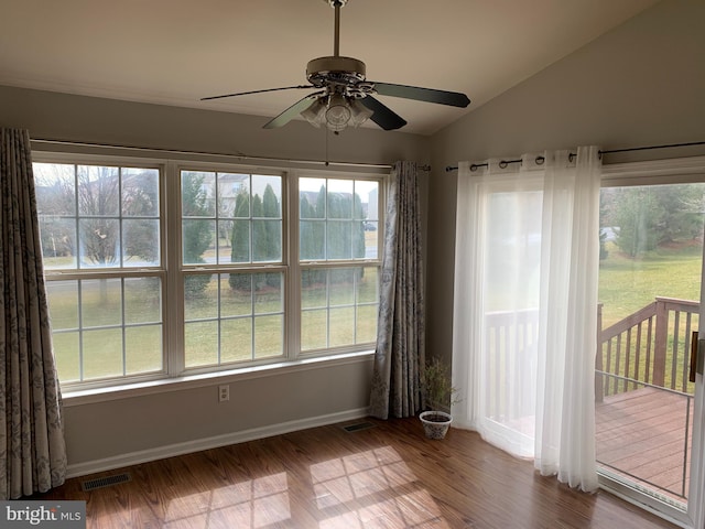 empty room with vaulted ceiling, wood finished floors, and visible vents