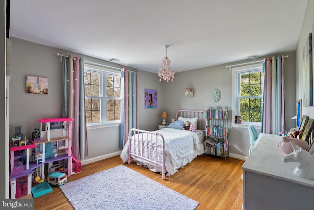 bedroom featuring baseboards, visible vents, and light wood-style floors