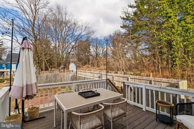 wooden terrace with outdoor dining area and fence