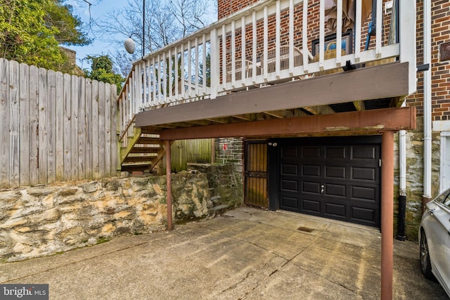 exterior space with a chimney, stairway, an attached garage, fence, and brick siding