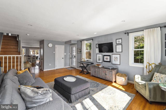 living room featuring stairway, recessed lighting, wood finished floors, and baseboards