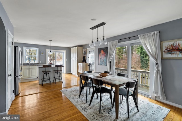 dining space with light wood finished floors and baseboards