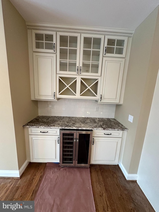 bar featuring tasteful backsplash, beverage cooler, and dark wood-type flooring