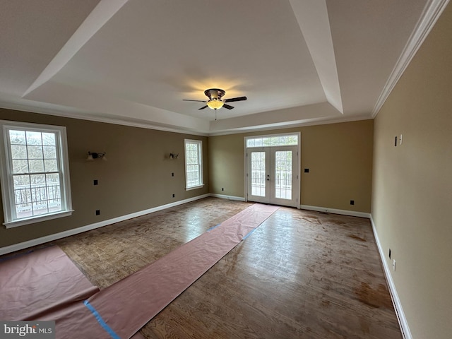 foyer featuring wood finished floors, a ceiling fan, baseboards, french doors, and a raised ceiling