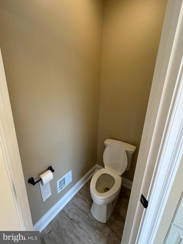 bathroom featuring visible vents, toilet, and baseboards