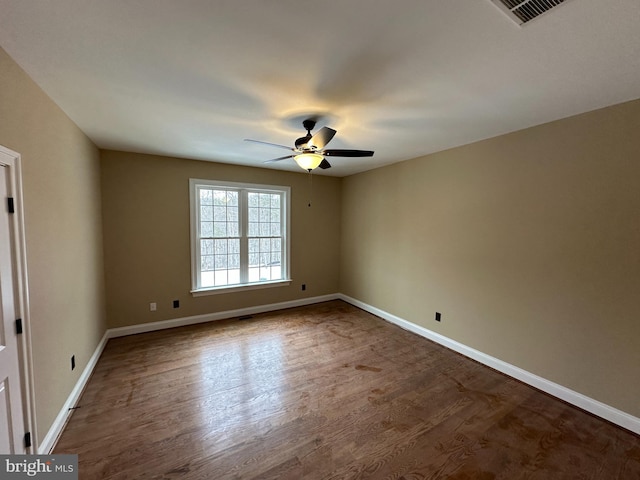 unfurnished room with baseboards, visible vents, ceiling fan, and wood finished floors