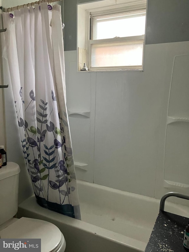 full bath featuring toilet and shower / bath combo with shower curtain