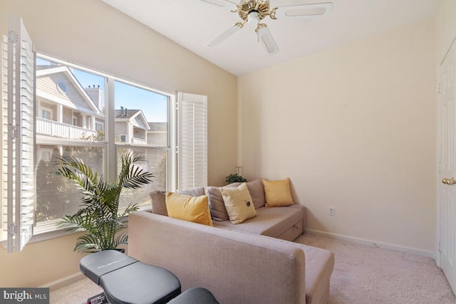 carpeted living area featuring lofted ceiling, ceiling fan, and baseboards