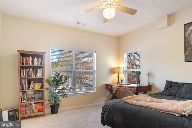 carpeted bedroom with a textured ceiling, visible vents, and baseboards