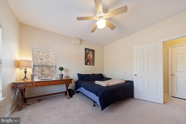 bedroom with baseboards, a ceiling fan, lofted ceiling, a textured ceiling, and carpet floors