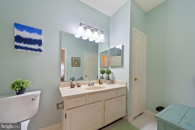 bathroom with tile patterned flooring, baseboards, vanity, and toilet