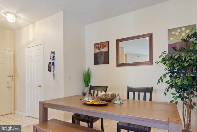 dining area featuring a textured ceiling and light tile patterned flooring