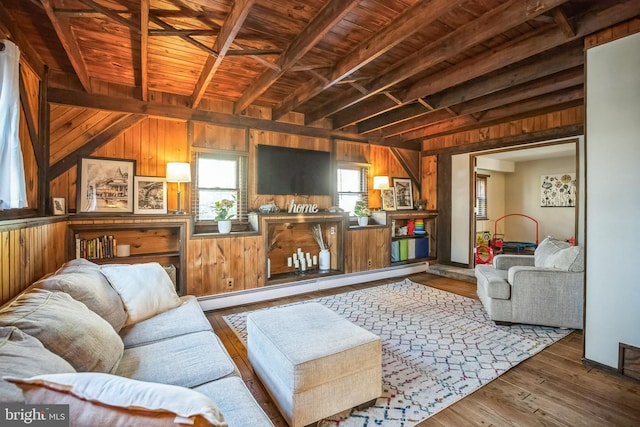 living room with a baseboard radiator, wood walls, wood finished floors, wooden ceiling, and beamed ceiling