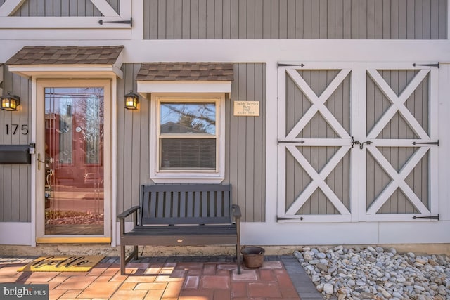 entrance to property with roof with shingles