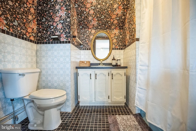 bathroom with tile walls, curtained shower, toilet, vanity, and tile patterned flooring