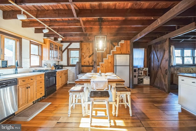 kitchen with dishwasher, wood ceiling, freestanding refrigerator, black gas stove, and beam ceiling