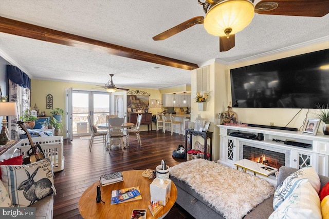 living area with ornamental molding, a lit fireplace, a textured ceiling, and hardwood / wood-style flooring