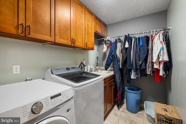 laundry room featuring a textured ceiling, separate washer and dryer, a sink, and cabinet space