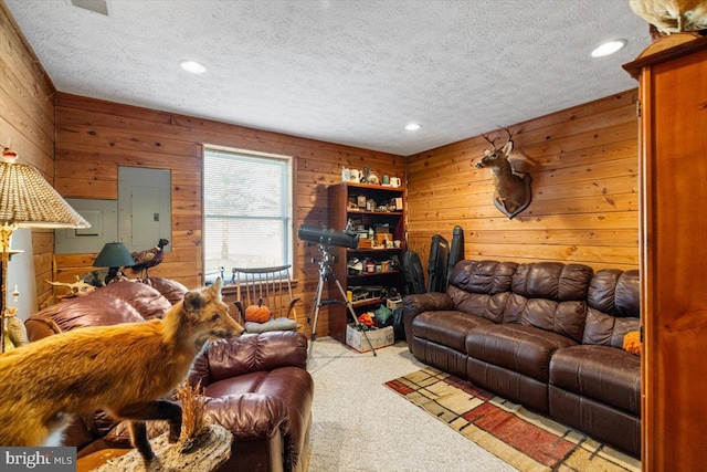 living room featuring a textured ceiling, carpet, electric panel, and wooden walls