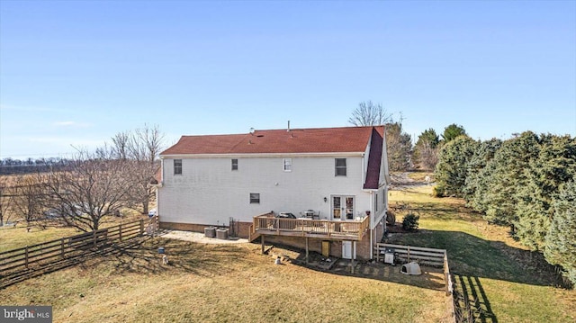 back of property featuring a lawn, a wooden deck, and fence