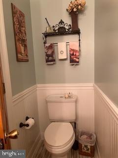 bathroom featuring wainscoting and toilet