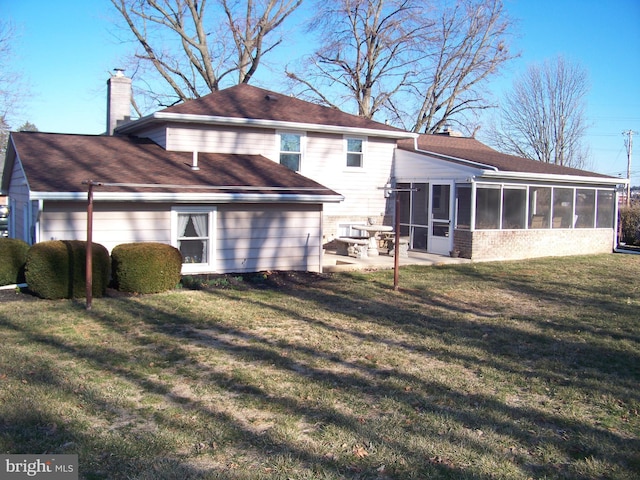 back of property featuring a sunroom, a patio area, a chimney, and a lawn