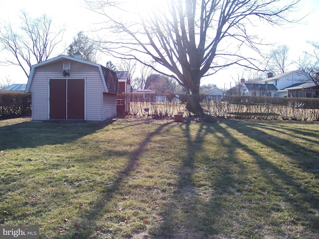 view of yard featuring a shed, fence, and an outdoor structure