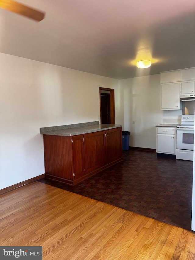 kitchen featuring white range with electric cooktop, white cabinets, wood finished floors, under cabinet range hood, and baseboards