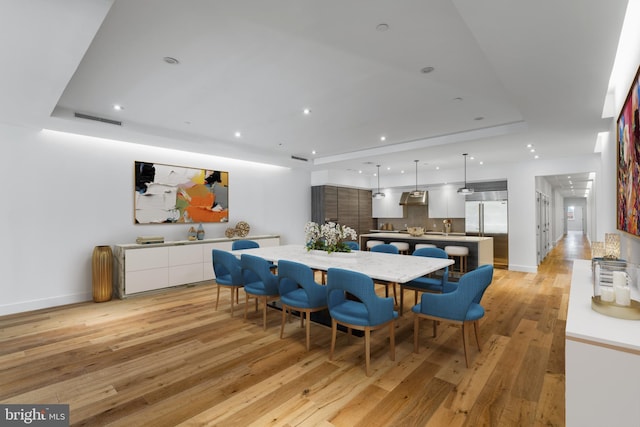 dining area with recessed lighting, visible vents, baseboards, light wood-style floors, and a raised ceiling